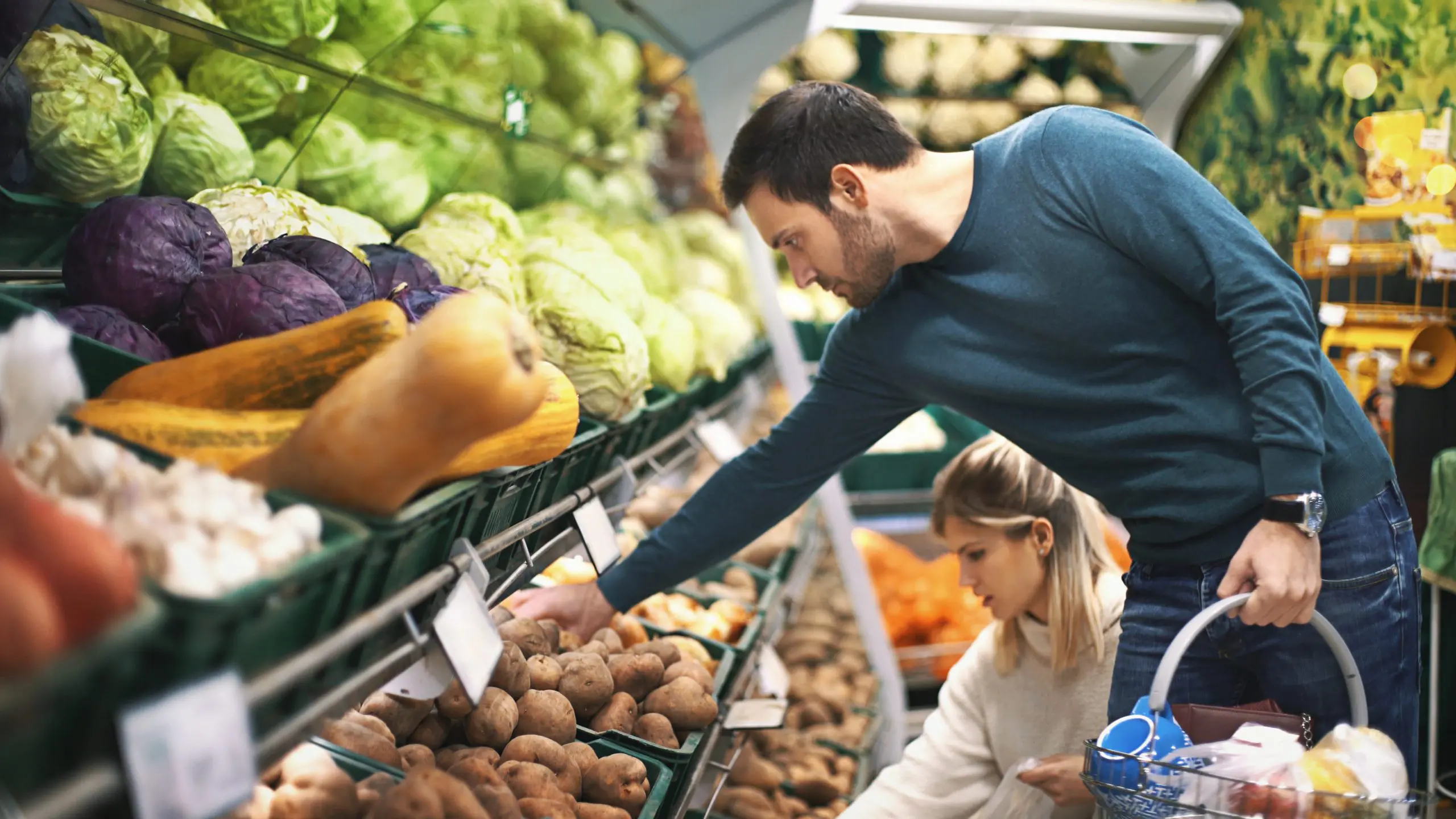 Young couple buying fruit and vegetables at the supermarket