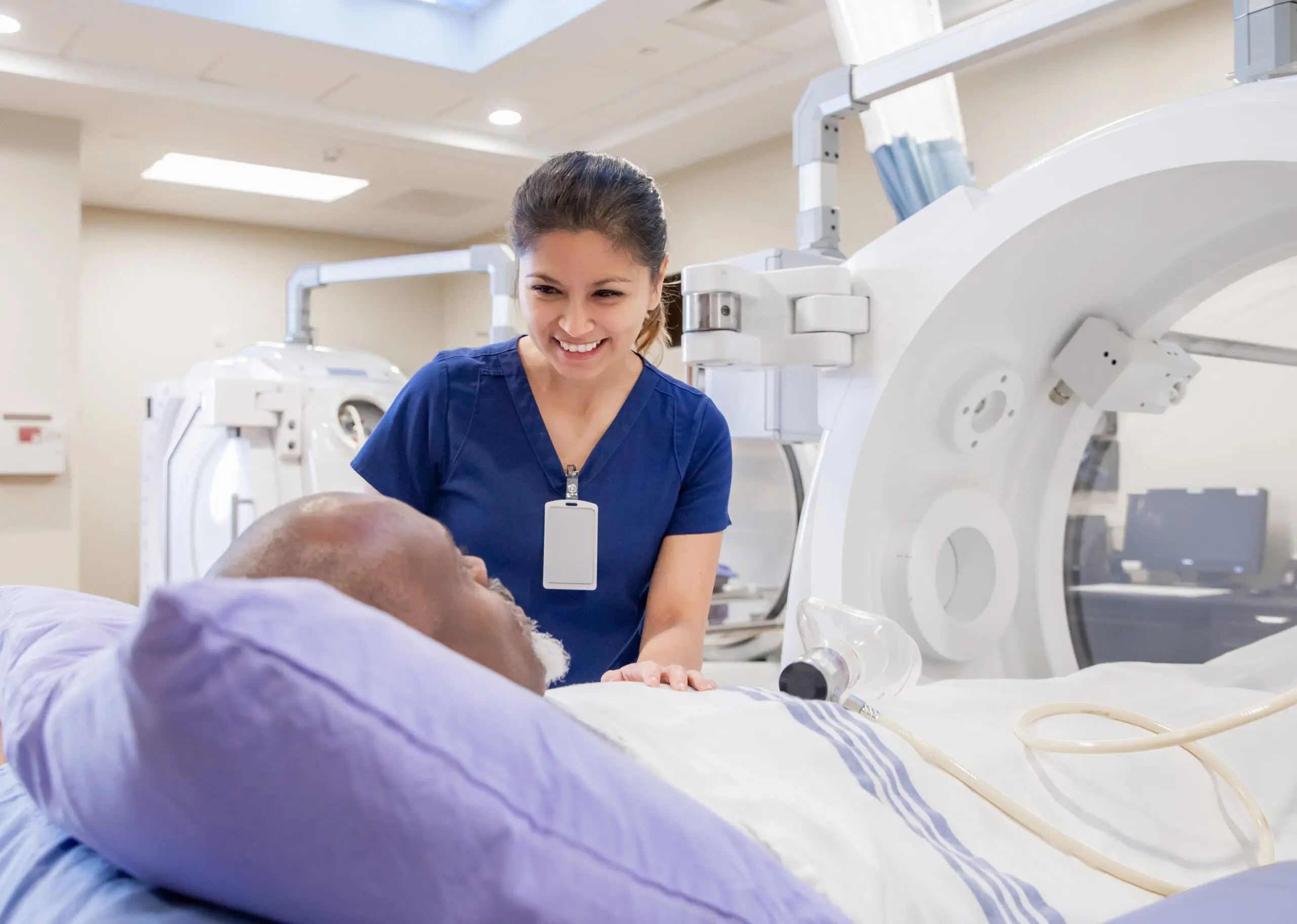 Female nurse prepares senior male for treatment