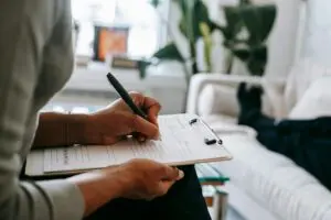 A person writing on a clipboard in hospital