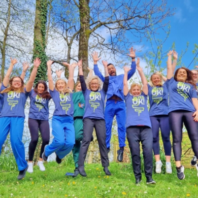 A group of people waring Guts UK t-shirts jumping in the air in celebration.