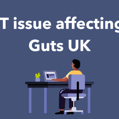 The text IT issues affecting Guts UK are written in white on a blue background, alongside an illustration of a person sat at a desk looking at their computer.