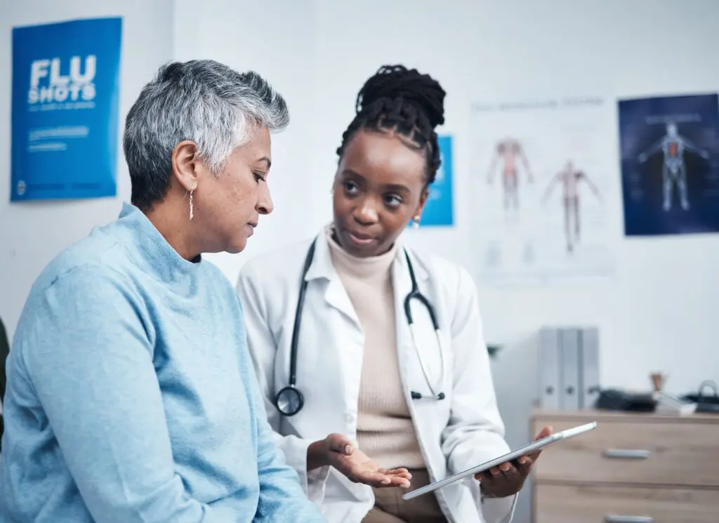 Black woman, doctor and senior patient with computer tablet.