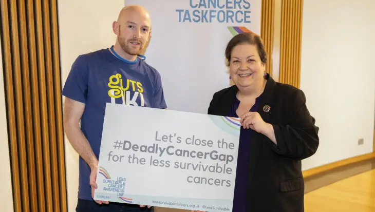 A photograph of Ross Marsden, patient and family advocate, and Jackie Baillie, Member of Scottish Parliament, stand together and smile at the camera.