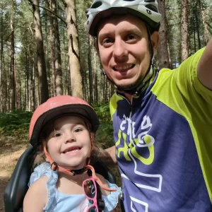 James and his daughter, Jaz, smiling for the camera with their helmets on after a bike ride