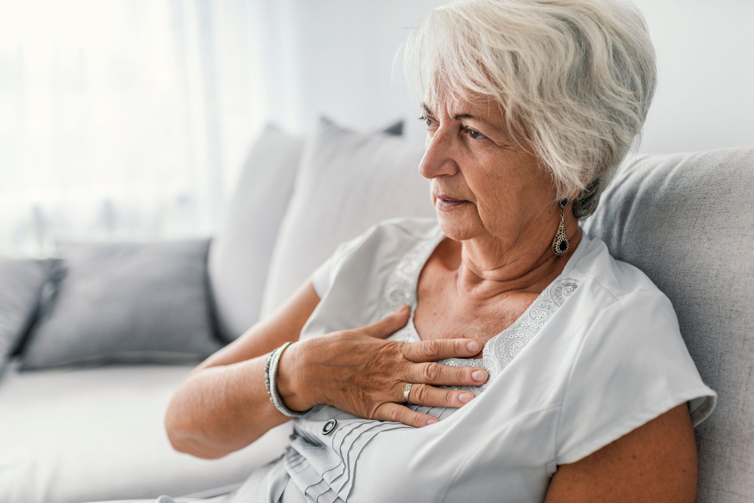 Woman has hand to her chest.