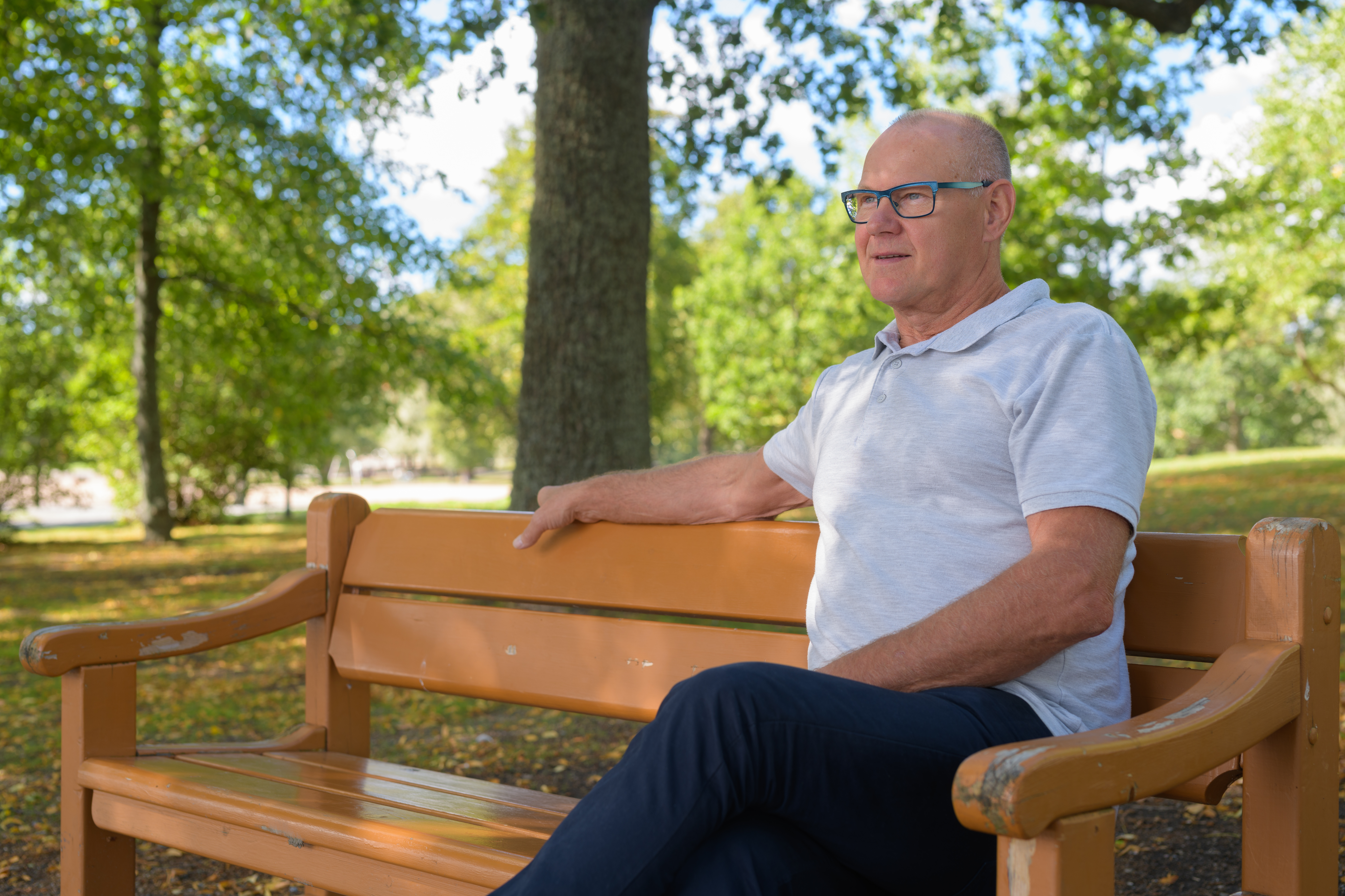 Man sitting on a bench in the park, thinking and looking ahead