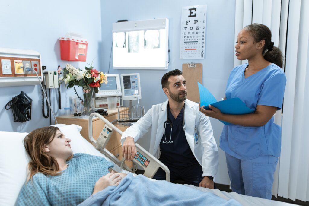 Doctor talking to a patient who is lying in a hospital bed