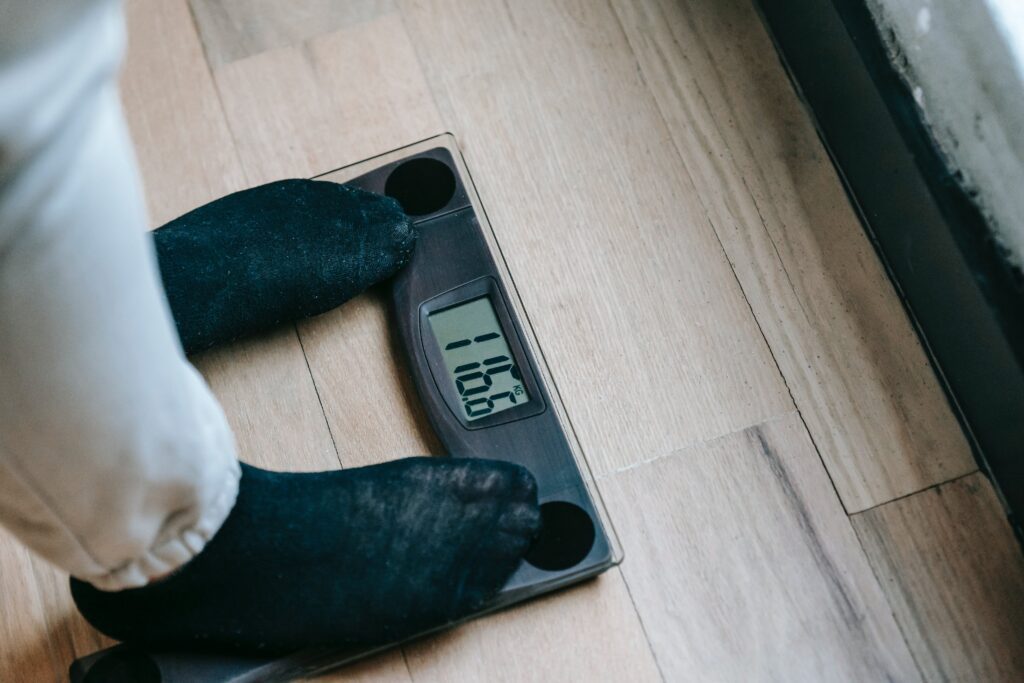 Cropped photo of feet wearing black socks standing on scales
