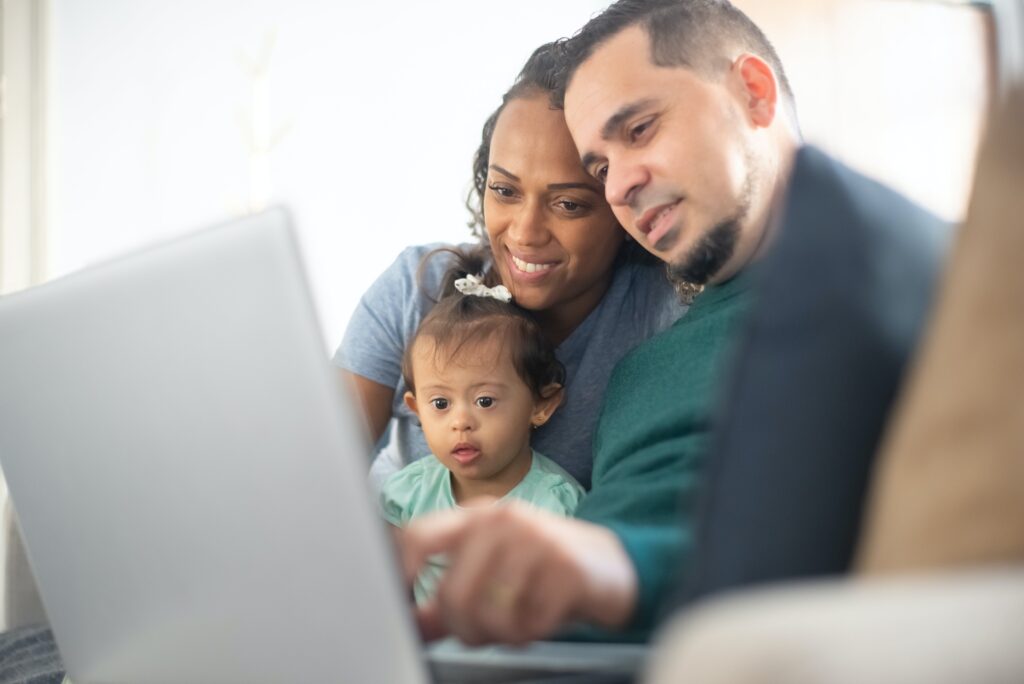 A family of three looking at a laptop