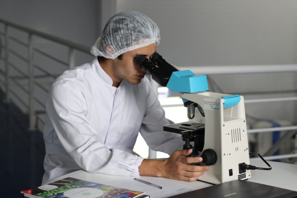 Researcher looking into a microscope in a lab