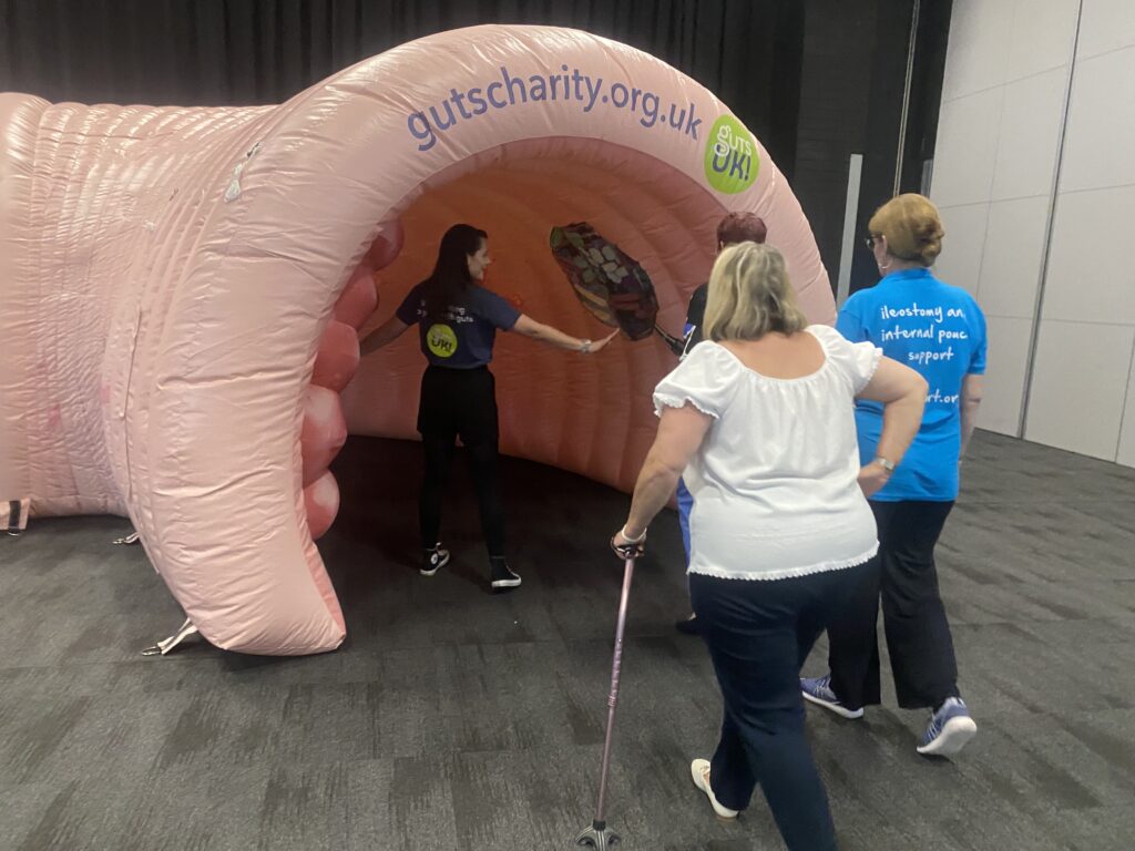 Amy is walking visitors into Colin the Inflatable Colon, showing them a healthy gut microbiota on the inner, right hand side of the colon.