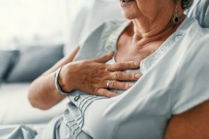 A female placing her hand on her chest.