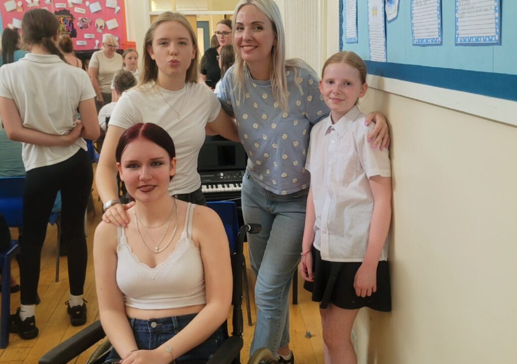 Leanne (centre) pictured with her three daughters in a school hall.