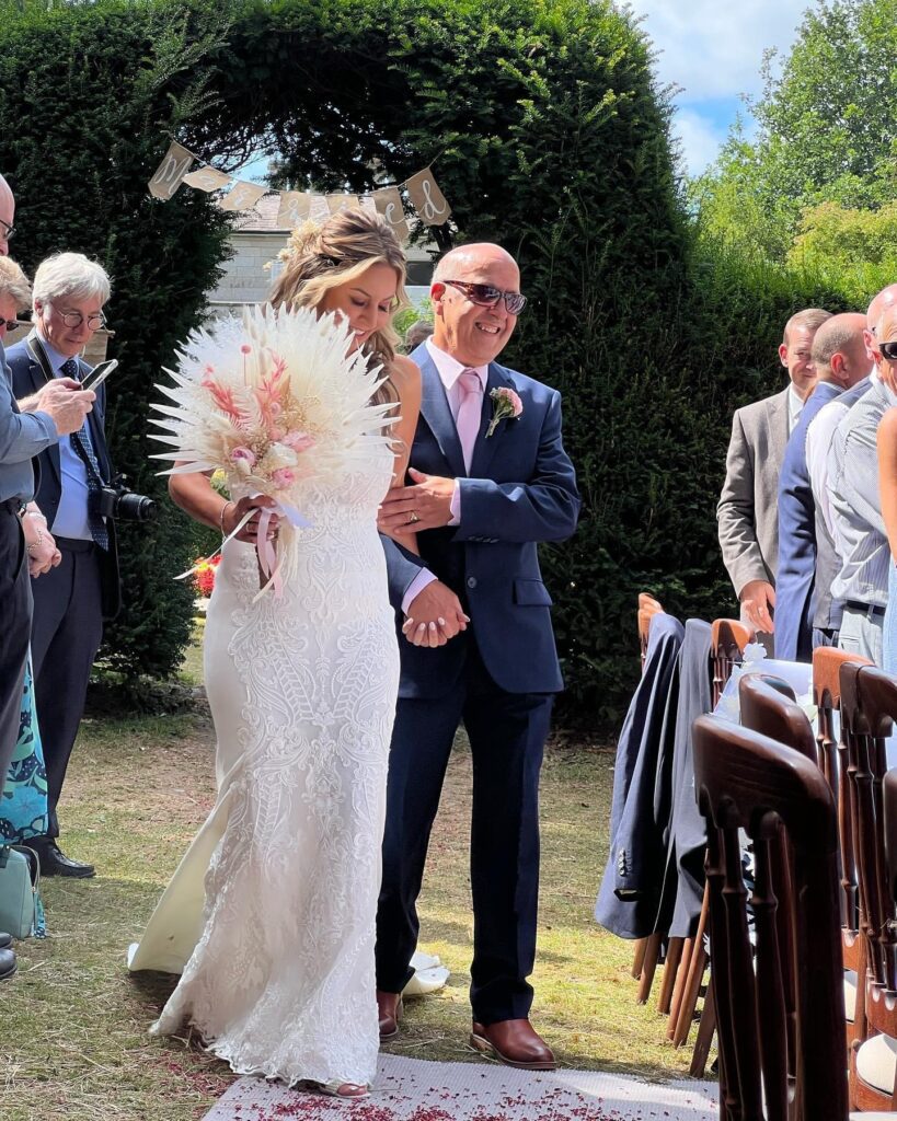 Sarah with her Dad, Charlie on her wedding day as he walks her down the aisle.