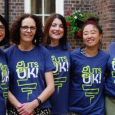 Guts UK team members smile for a photo wearing their Guts UK branded tshirts.